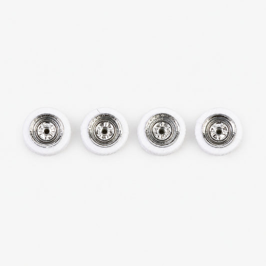 Four miniature chrome wheels with white tires, arranged in a row