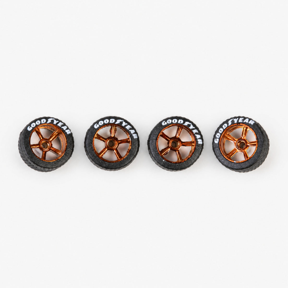 Four bronze five-spoke miniature wheels with black lettered tires