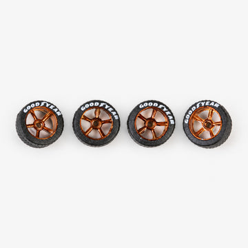 Four bronze five-spoke miniature wheels with black lettered tires
