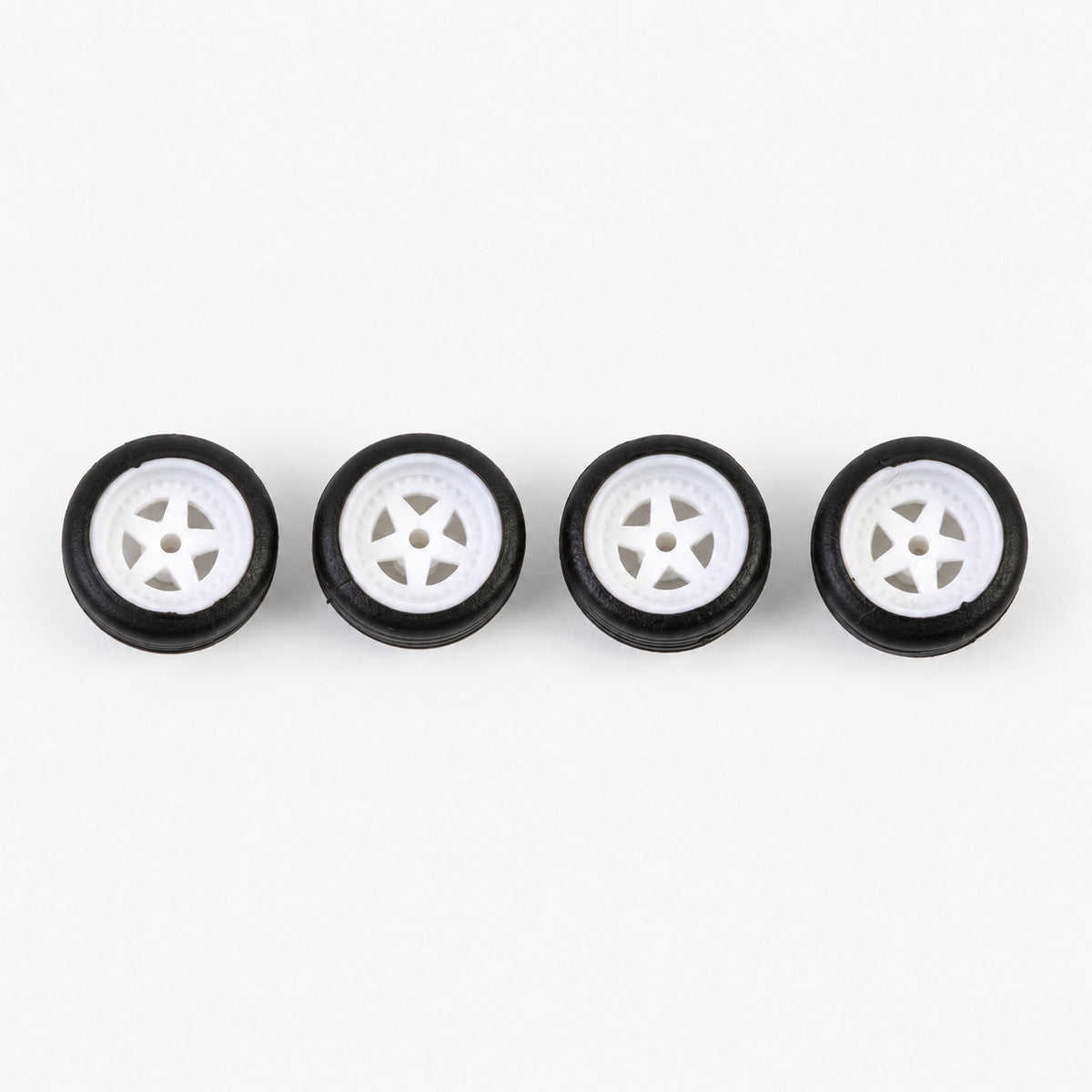 Four white five-spoke miniature wheels with black low-profile tires