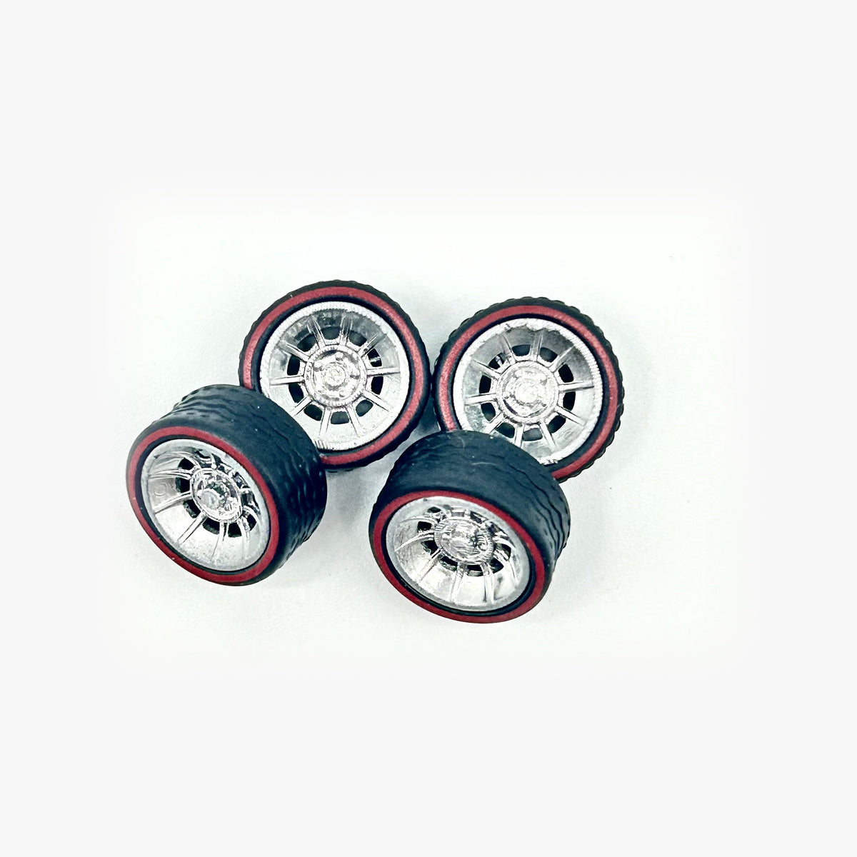 Four chrome Gen Lee-style miniature wheels with black tires and red sidewall rings